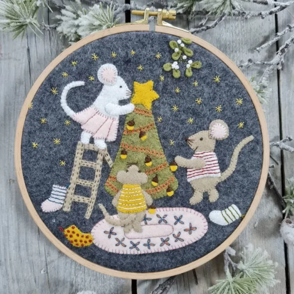 Felt mice embroidered onto a grey background and mounted in a wooden embroidery hoop.